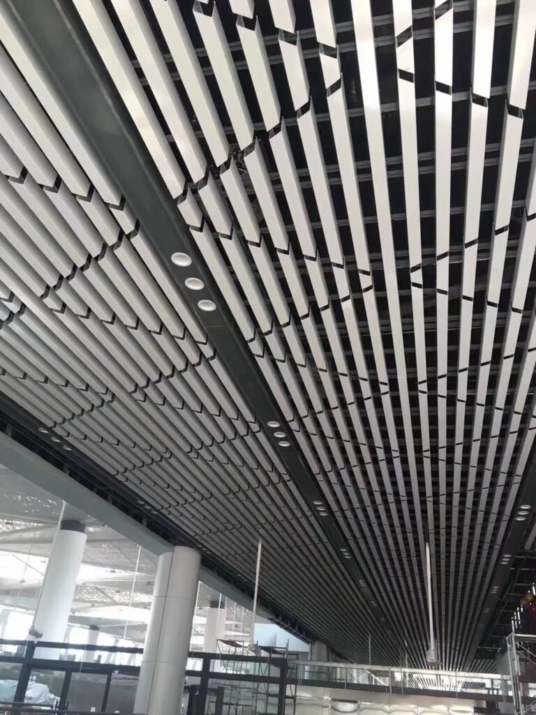 Black U-shaped aluminum baffle ceiling installed in a commercial interior