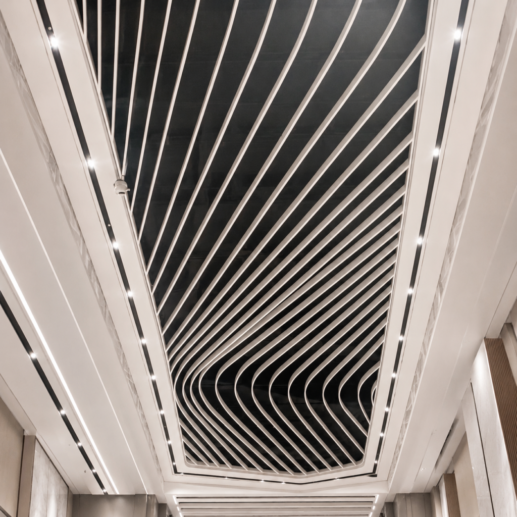 Black curved aluminum baffle ceiling with flowing wave-shaped design