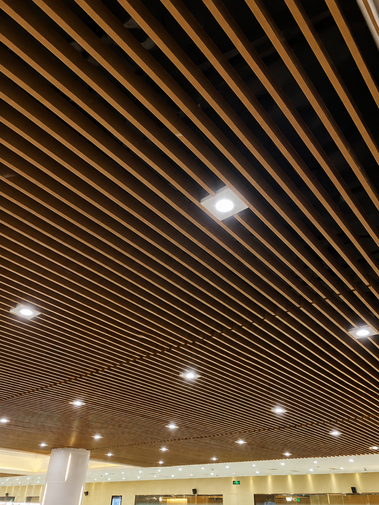 Wood grain recessed aluminum baffle ceiling installed in a commercial interior