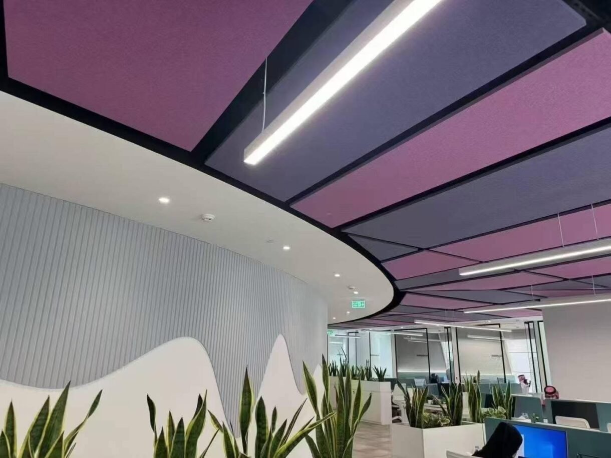 Custom fiberglass acoustic panels in purple and blue installed on a modern office ceiling.