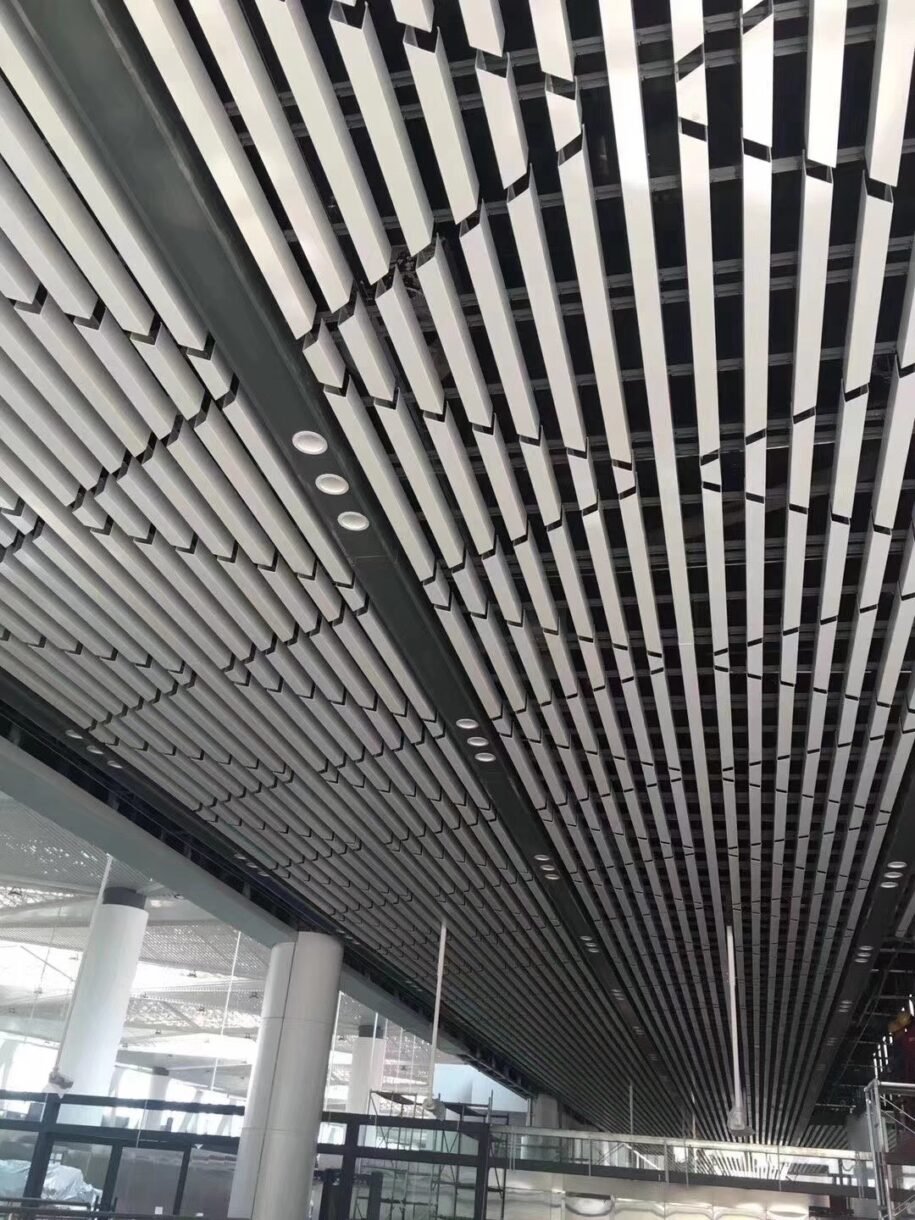 Linear aluminum vertical baffles installed on a large commercial ceiling for a modern architectural look.