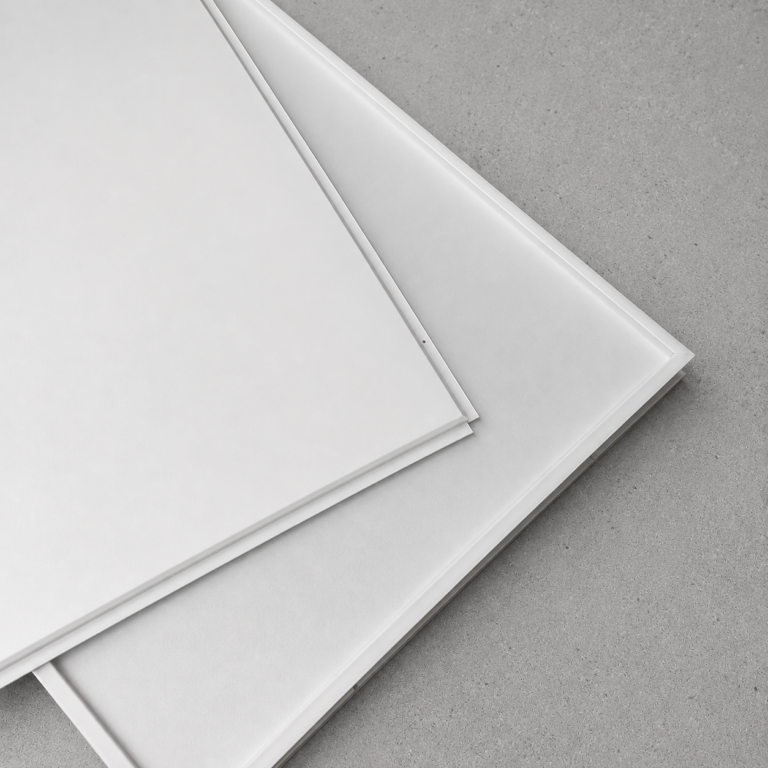 Close-up product sample of white aluminum lay-in ceiling tiles highlighting the tegular edge design.