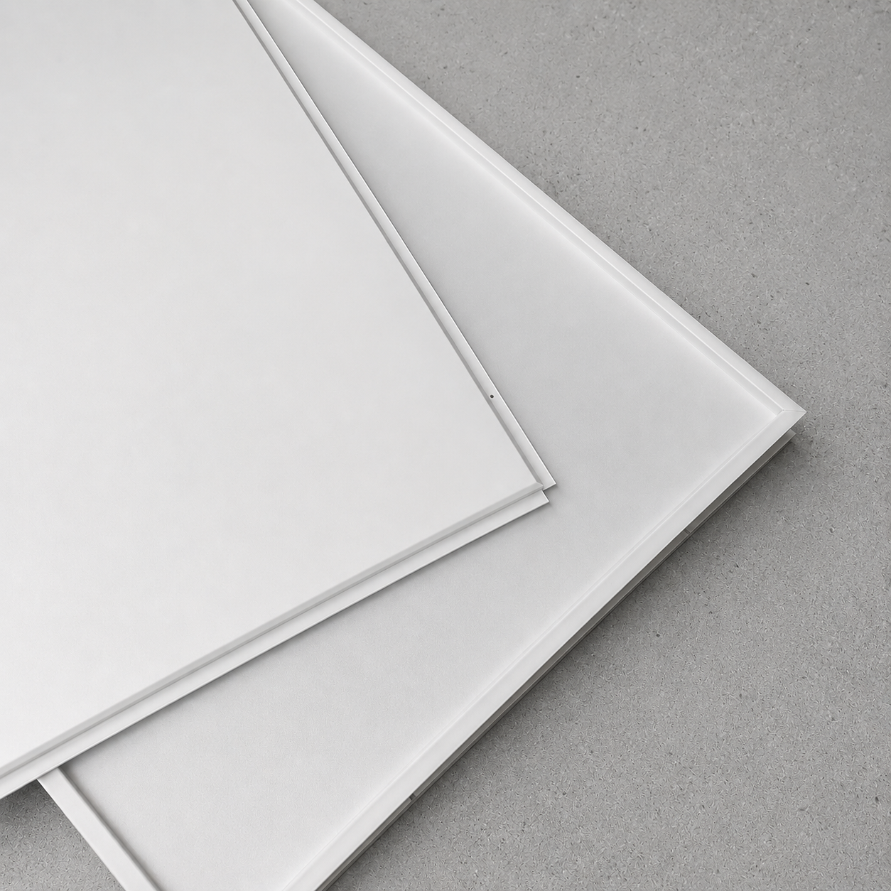 Close-up product sample of white aluminum lay-in ceiling tiles highlighting the tegular edge design.