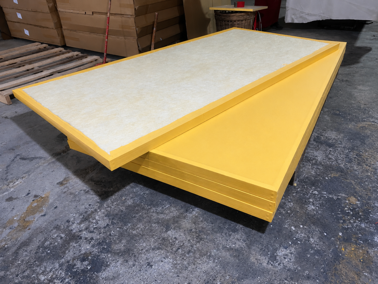Yellow fabric-wrapped fiberglass acoustic panels with exposed fiberglass core
