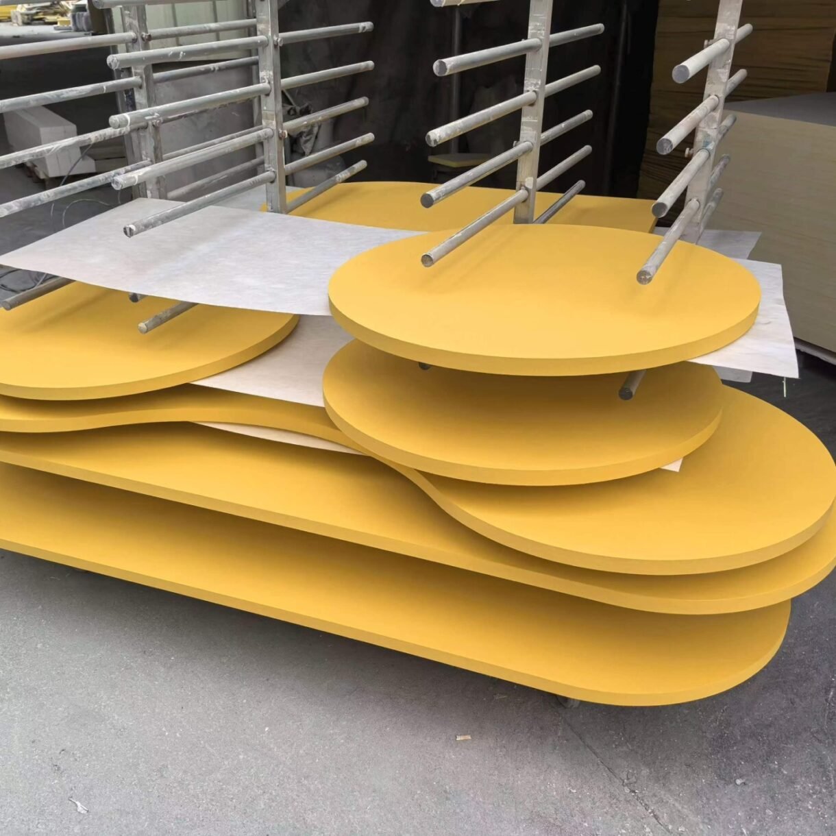 Stacked, custom-shaped yellow fiberglass acoustic panels with smooth edges, as shown in the attachment details for this guide.